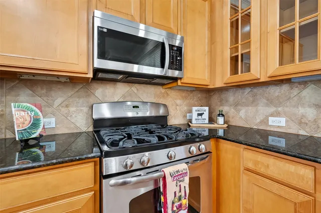 a kitchen with stainless steel appliances granite countertop a stove and a microwave