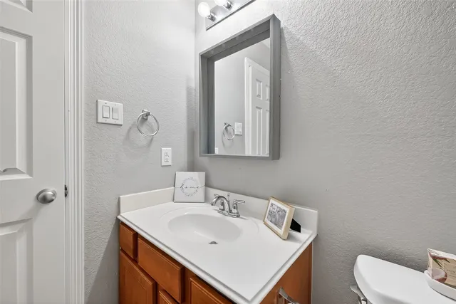 a bathroom with a sink mirror and toilet