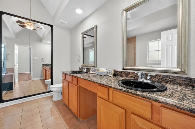 a bathroom with a granite countertop sink a mirror a and a window