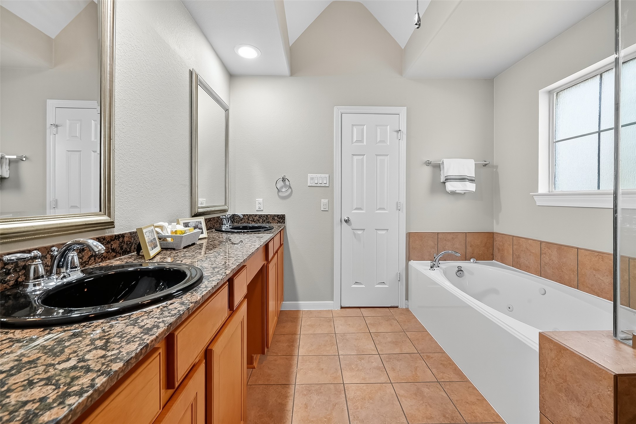 3019 Clearview Circle Houston, TX 77025 - Photo 38 of 42 a bathroom with a tub sink a mirror a vanity and window