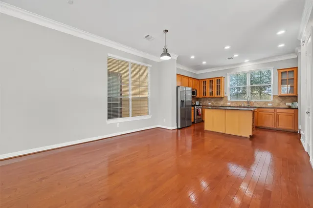 a view of a kitchen with a sink stove cabinets and empty room