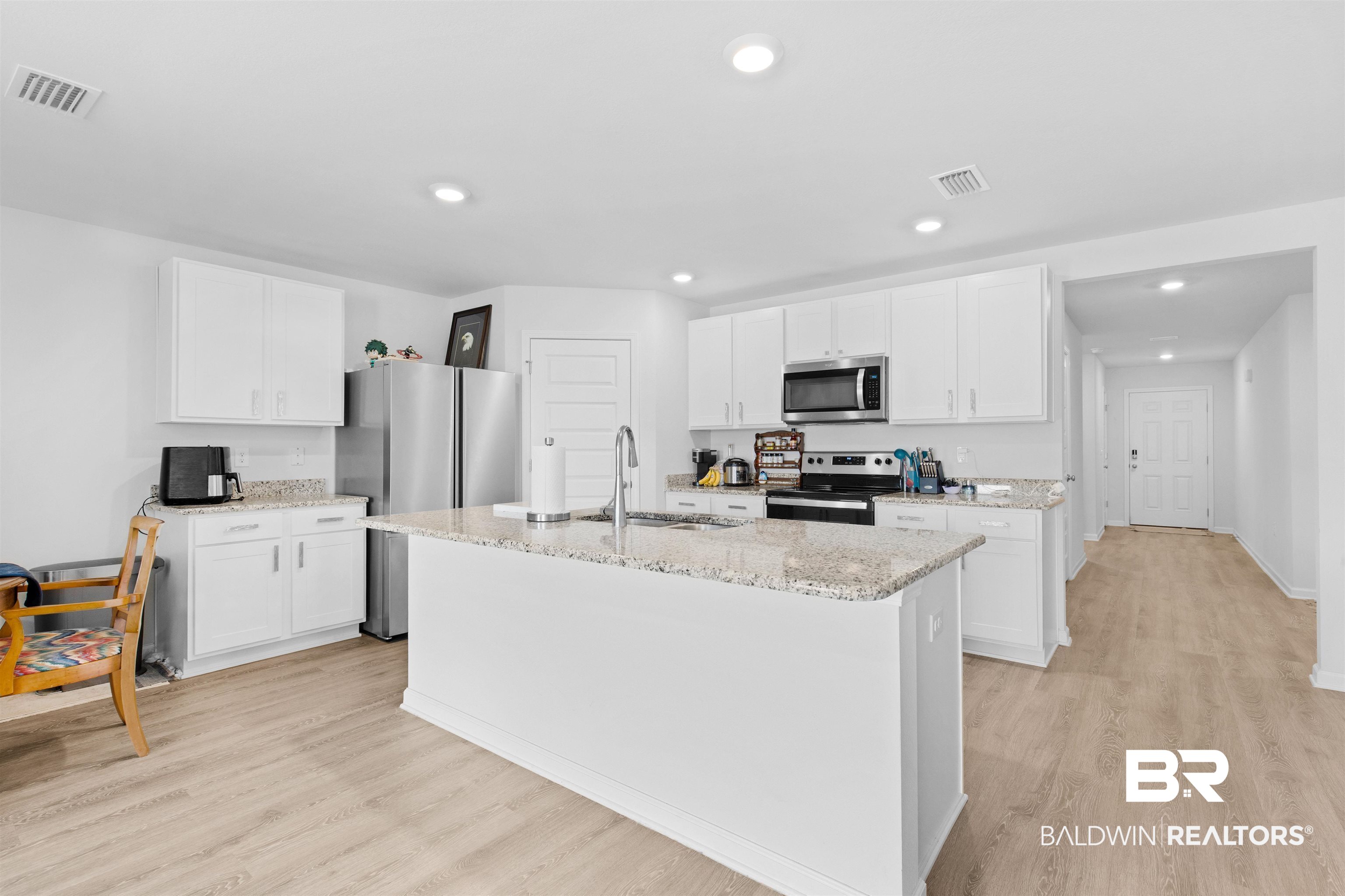 10261 Ruffian Route Daphne, AL 36526 - Photo 2 of 28 Kitchen with a sink, visible vents, light wood finished floors, and stainless steel appliances
