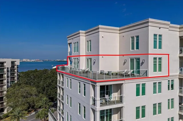 a large white kitchen with lots of counter top space a refrigerator a dining table and chairs