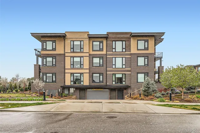 a front view of a residential apartment building with a yard
