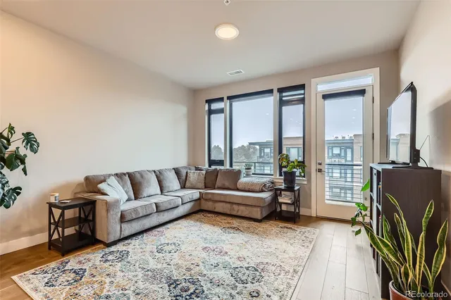 a living room with furniture potted plant and a large window