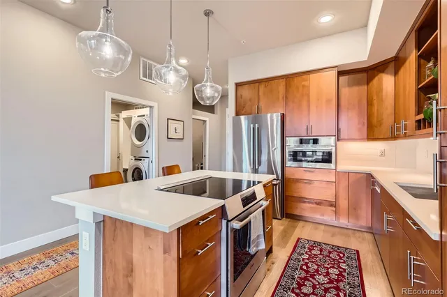 a kitchen with stainless steel appliances granite countertop a sink a refrigerator and a stove