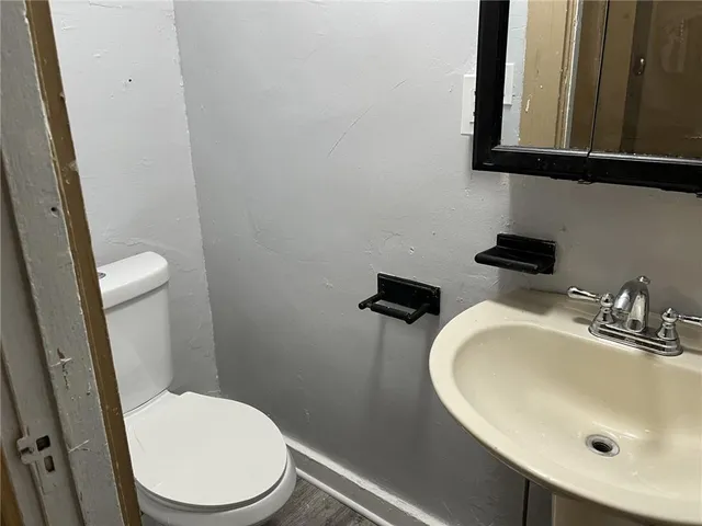 a bathroom with a sink a toilet and a mirror