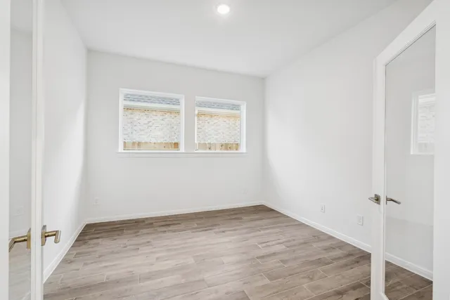 a view of an empty room with wooden floor