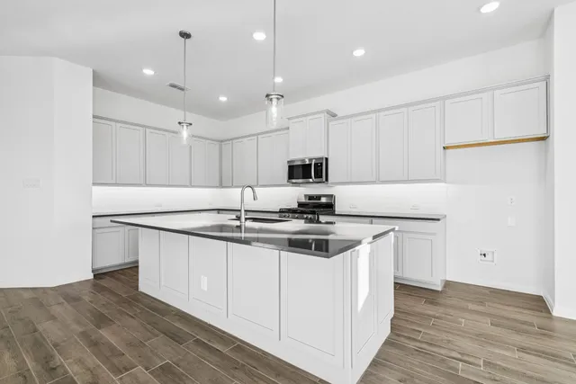 a kitchen with stainless steel appliances granite countertop a sink stove and refrigerator