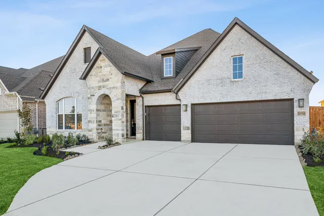 a front view of a house with yard and garage