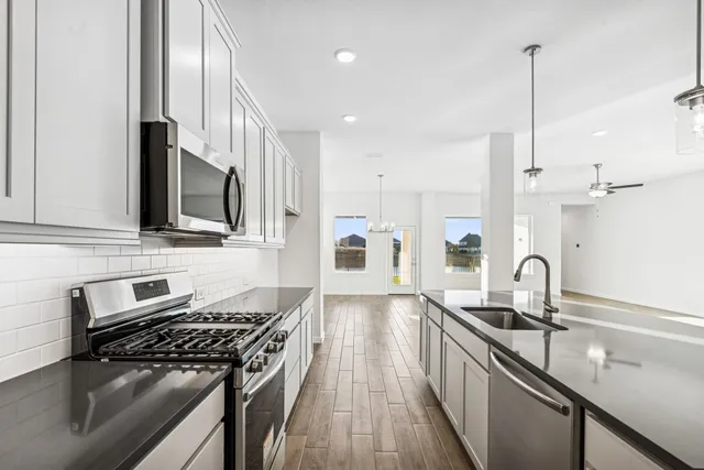 a kitchen with kitchen island stainless steel appliances a sink a stove a counter space and cabinets