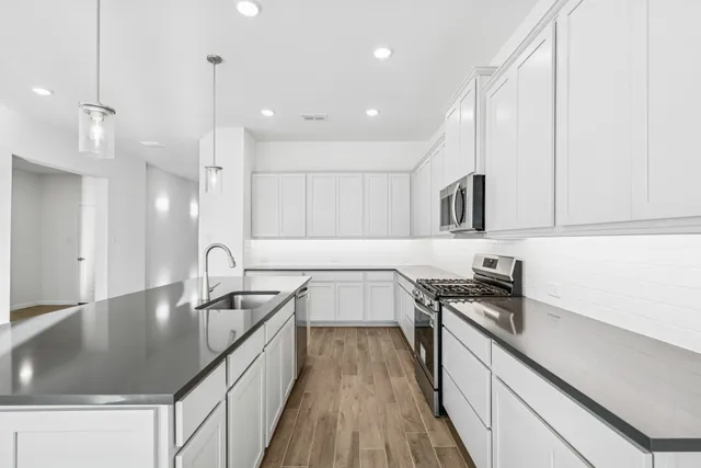 a kitchen with stainless steel appliances granite countertop a sink stove and wooden floor