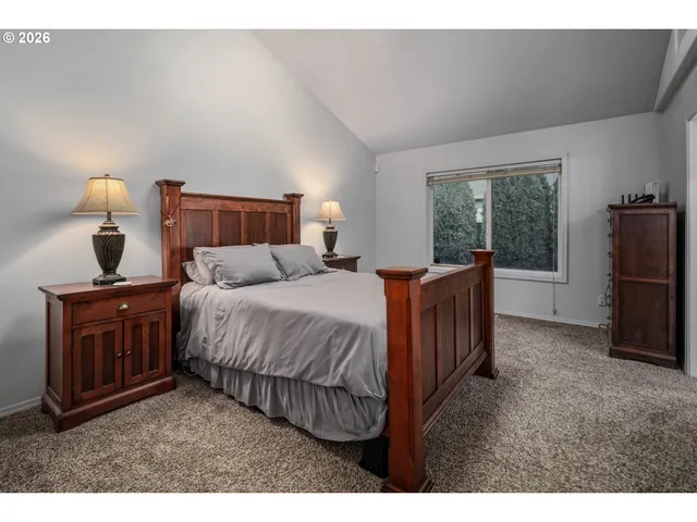 a bedroom with a bed and a flat tv screen on dresser