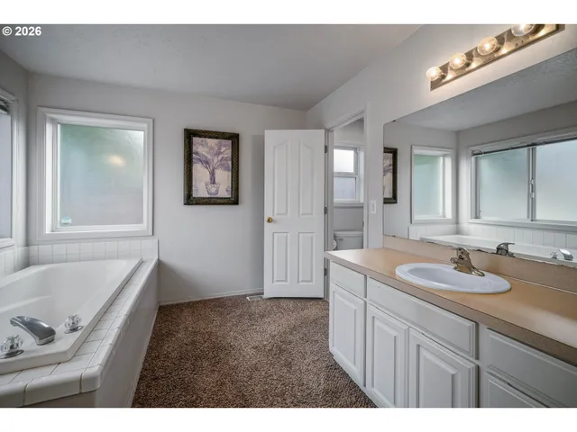 a bathroom with a tub sink and mirror