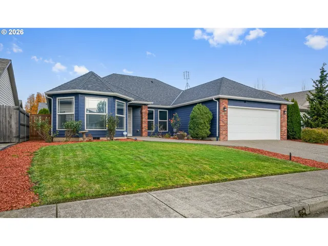 a front view of a house with a garden and yard