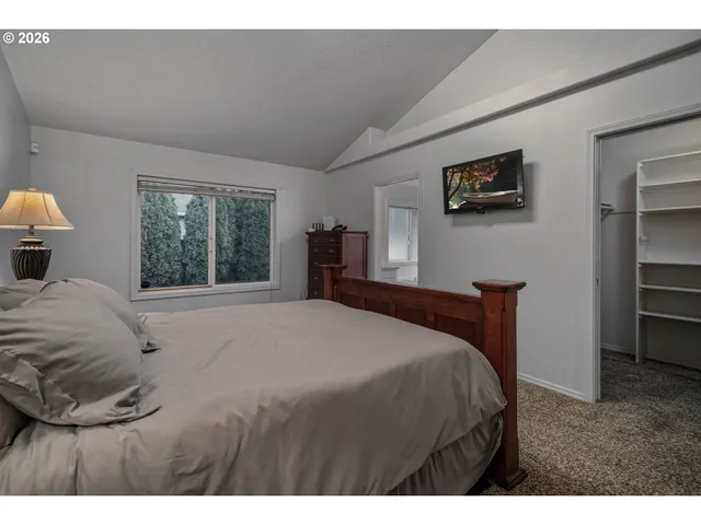 a bedroom with a large bed and a window