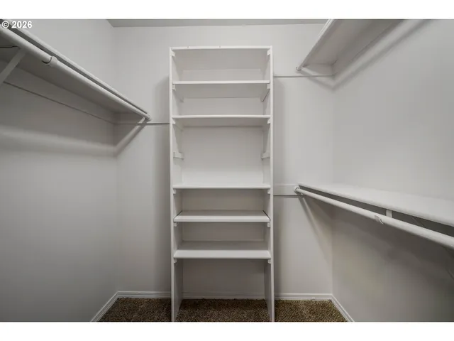a view of walk in closet with empty racks