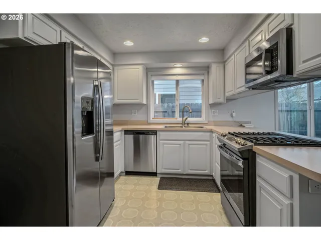 a kitchen with stainless steel appliances a sink stove and refrigerator