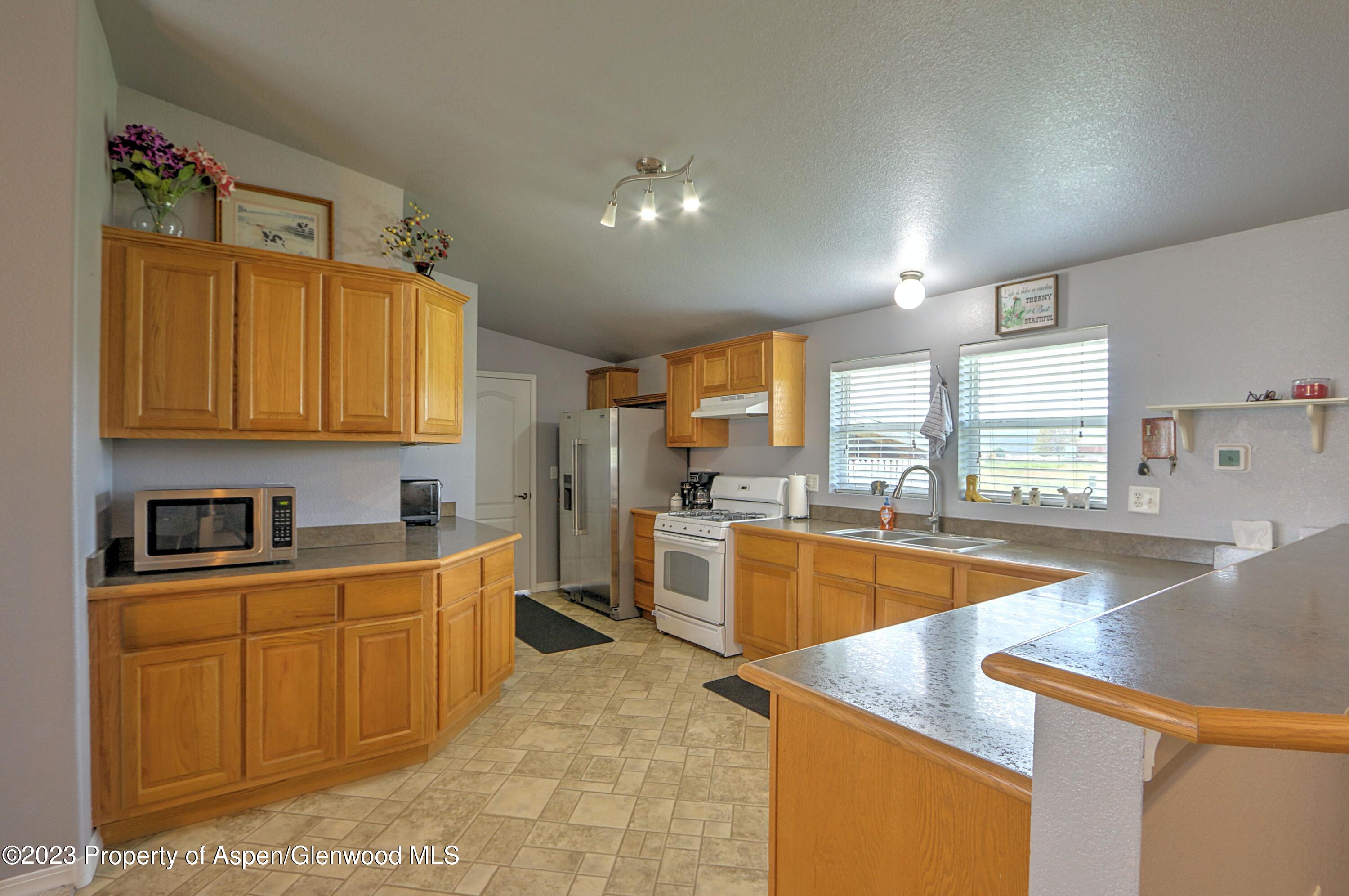 2517 210 County Road Rifle, CO 81650 - Photo 11 of 41 a large kitchen with stainless steel appliances lots of counter space sink and cabinets