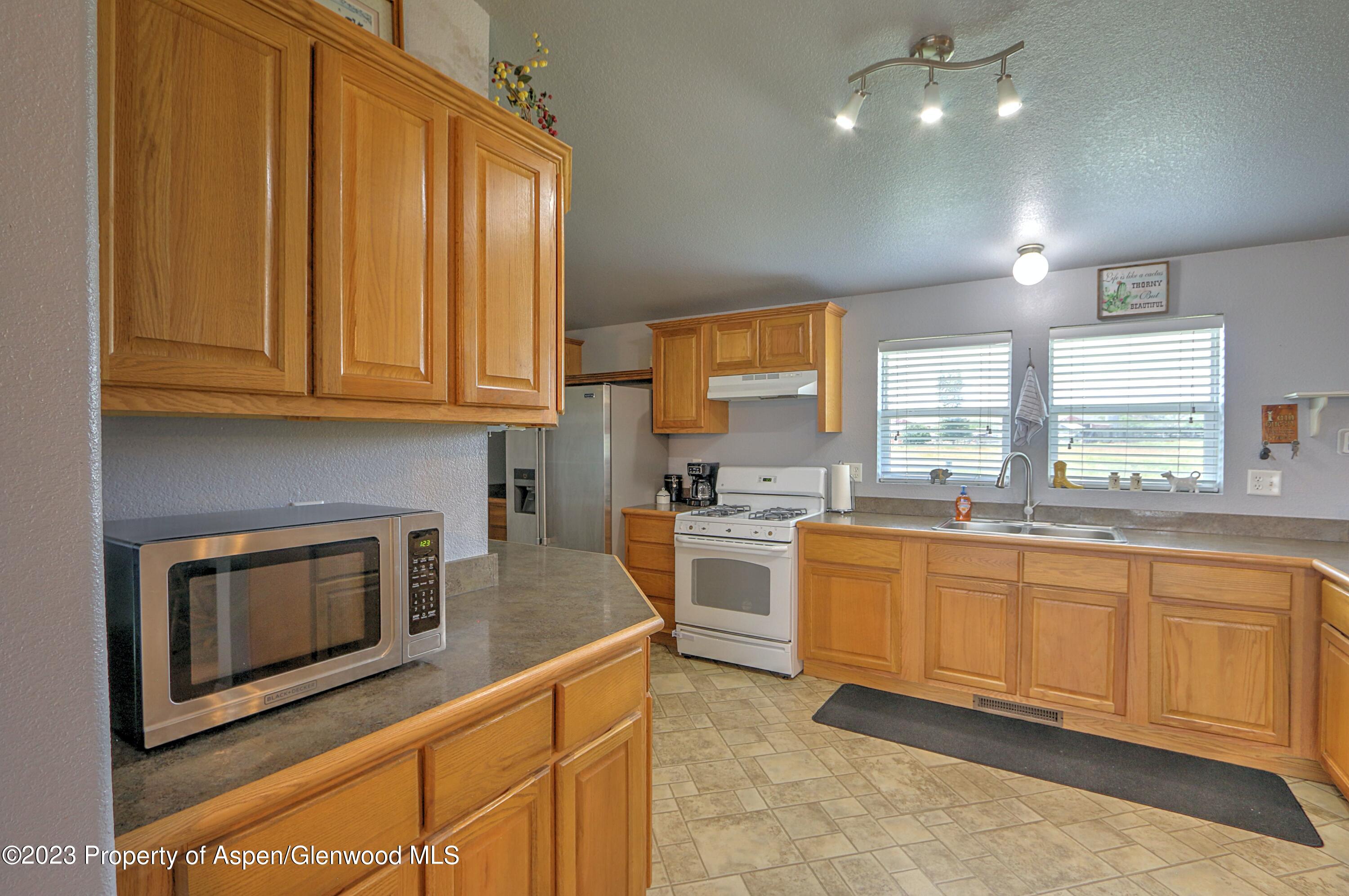 2517 210 County Road Rifle, CO 81650 - Photo 12 of 41 a kitchen with stainless steel appliances granite countertop a stove a sink and a microwave