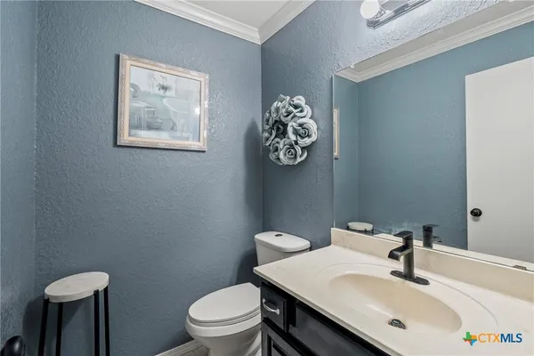 a bathroom with a sink mirror and a toilet