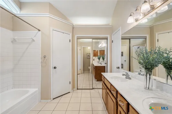 a bathroom with a granite countertop sink a mirror and a bathtub