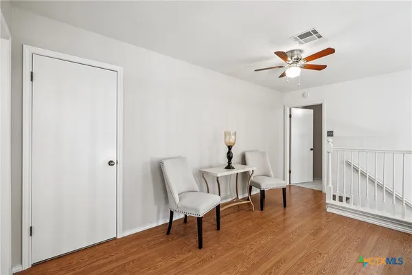 a view of a room with furniture and wooden floor