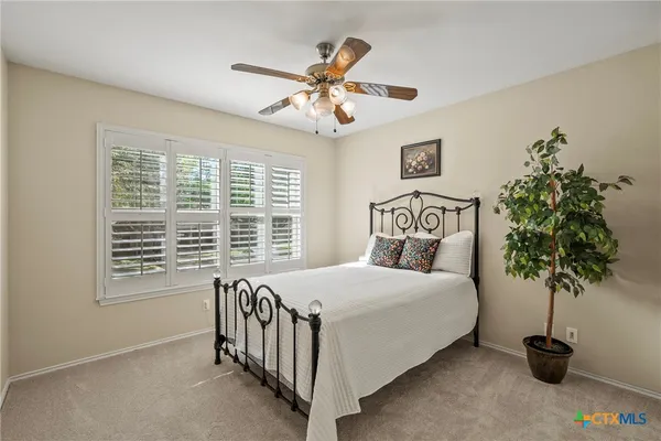 a bedroom with a bed and a potted plant
