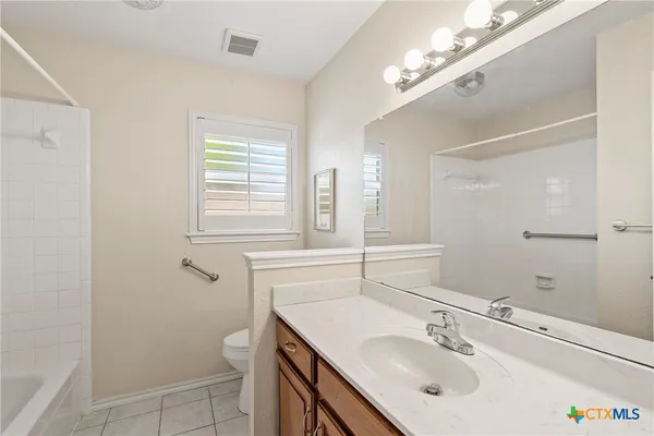 a bathroom with a sink shower and a mirror