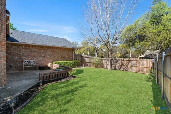 a view of backyard with seating area and green space