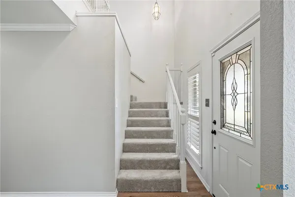 a view of staircase with white walls and windows
