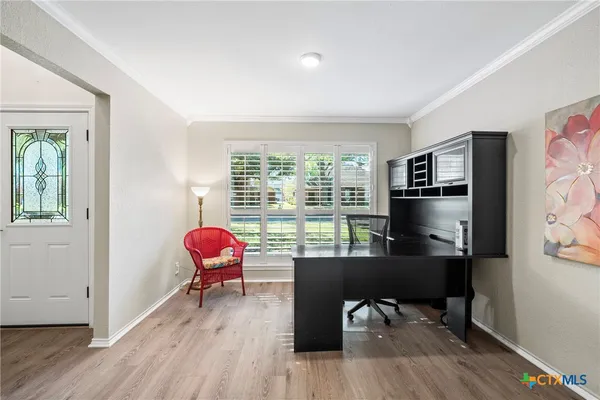 a view of a workspace with furniture and a window