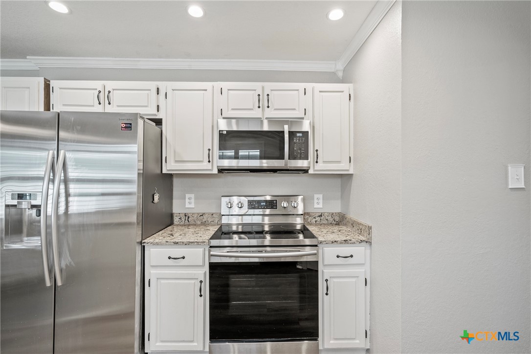 4518 Stagecoach Trail Temple, TX 76502 - Photo 9 of 29 a kitchen with stainless steel appliances white cabinets and a stove top oven