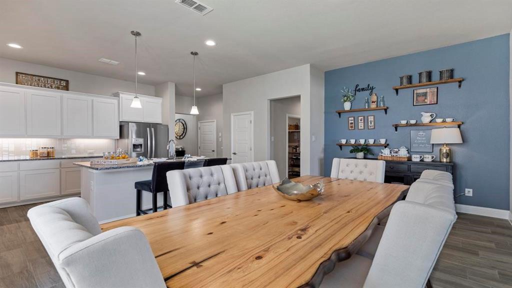 11205 Treehouse Trail Justin, TX 76247 - Photo 9 of 39 a large kitchen with kitchen island a white counter space a sink cabinets and appliances