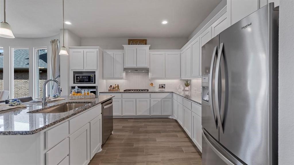11205 Treehouse Trail Justin, TX 76247 - Photo 2 of 39 a kitchen with stainless steel appliances granite countertop a refrigerator and a sink