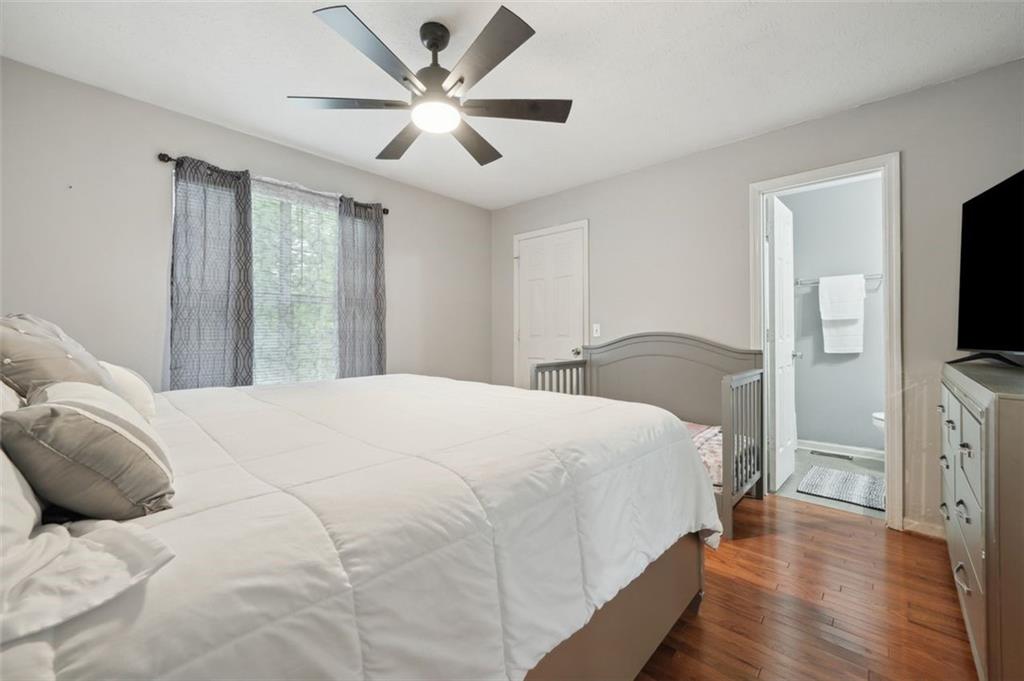 6420 Marbut Road Lithonia, GA 30058 - Photo 16 of 29 a bedroom with a large bed and a flat tv screen on dresser
