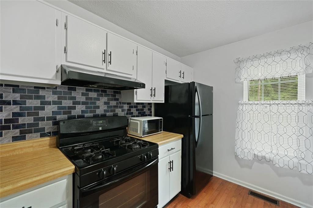 6420 Marbut Road Lithonia, GA 30058 - Photo 9 of 29 a kitchen with stainless steel appliances granite countertop a stove and a refrigerator