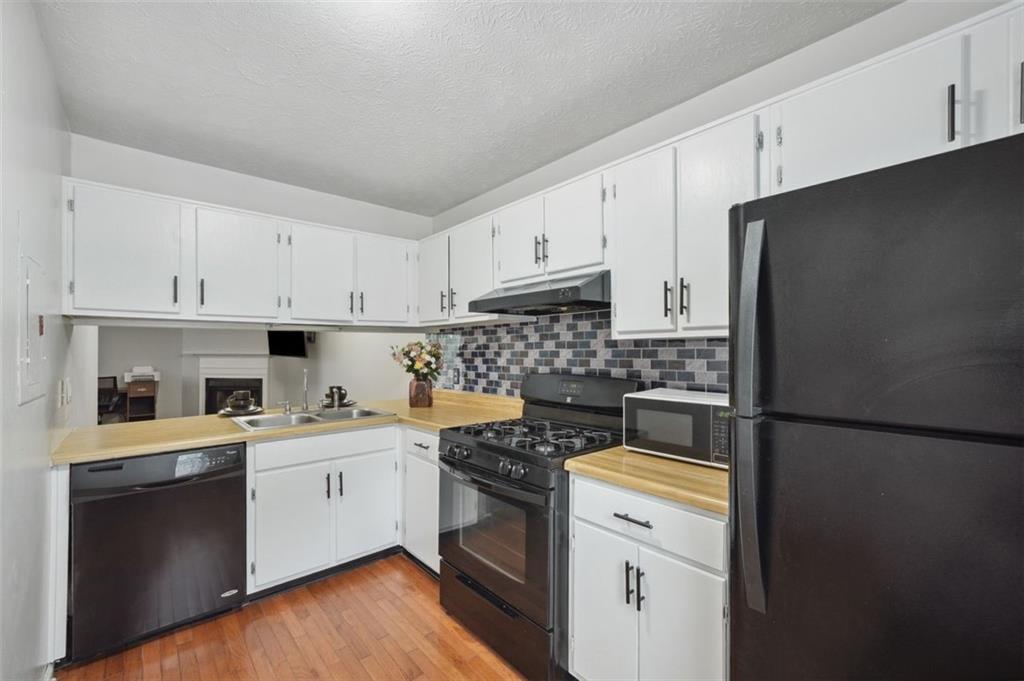 6420 Marbut Road Lithonia, GA 30058 - Photo 10 of 29 a kitchen with a refrigerator stove and white cabinets