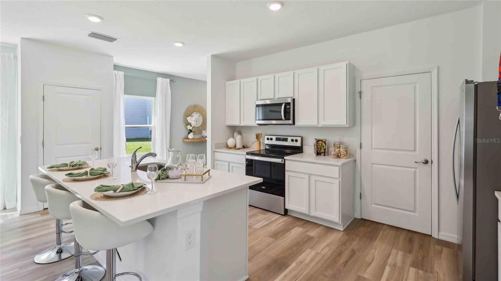24478 Northwest 10th Road Newberry, FL 32669 - Photo 5 of 24 a kitchen with white cabinets and stainless steel appliances