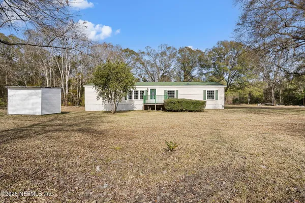 a front view of a house with a yard and trees