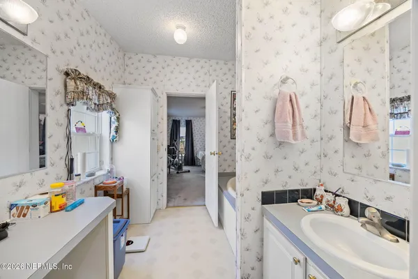 a bathroom with a sink mirror and shower