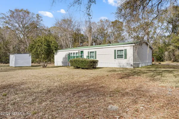 a front view of house with yard and trees around
