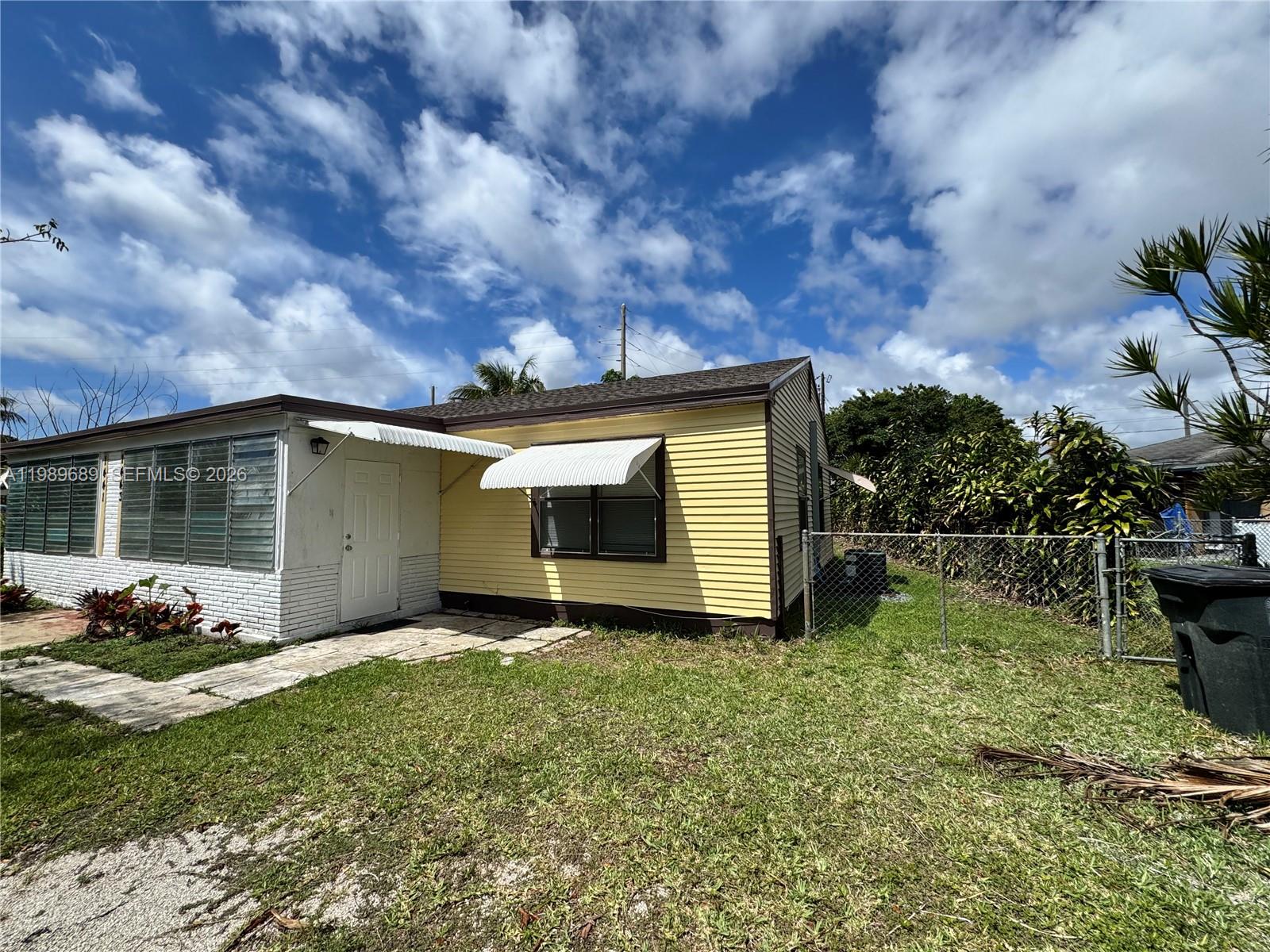 1441 Northeast 134th Road, Unit 2 North Miami, FL 33161 - Photo 12 of 16 a view of a backyard with potted plants and a large tree