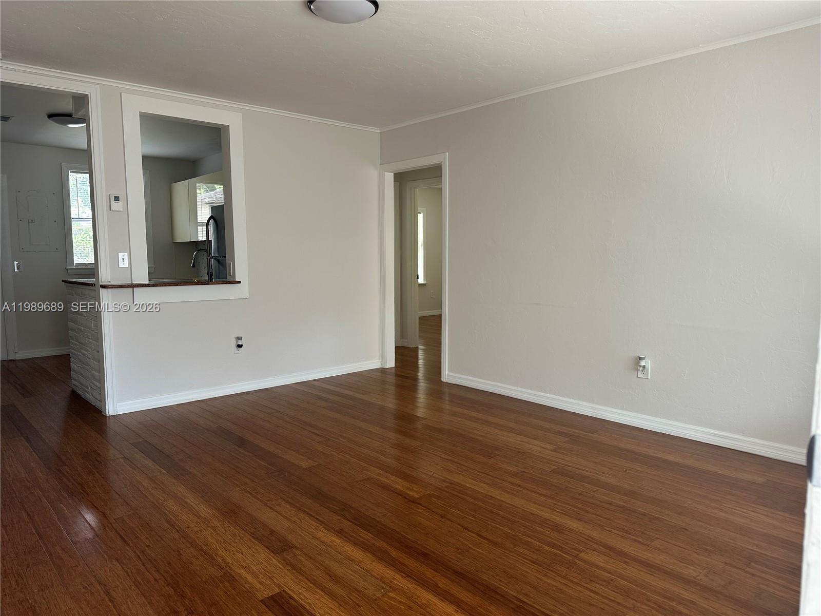 1441 Northeast 134th Road, Unit 2 North Miami, FL 33161 - Photo 2 of 16 an empty room with wooden floor and mirror