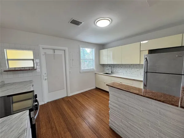 a kitchen with a refrigerator and a stove top oven