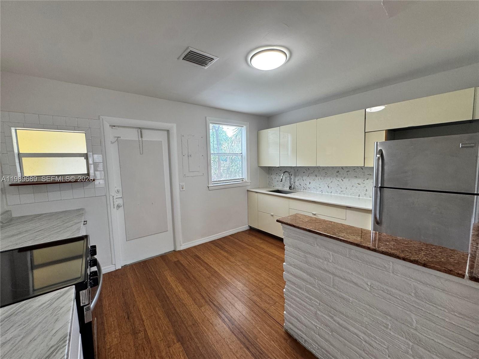 1441 Northeast 134th Road, Unit 2 North Miami, FL 33161 - Photo 6 of 16 a kitchen with a refrigerator and a stove top oven