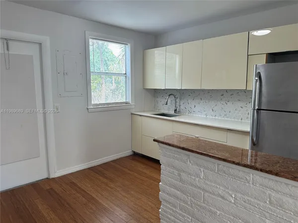 a kitchen with a sink cabinets stainless steel appliances and a window