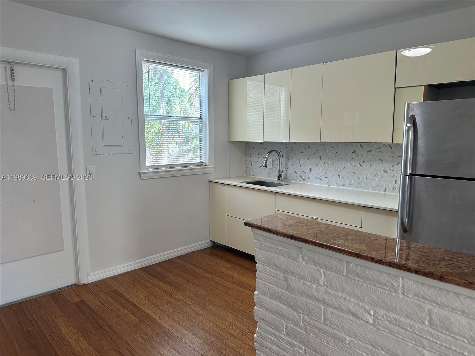 1441 Northeast 134th Road, Unit 2 North Miami, FL 33161 - Photo 7 of 16 a kitchen with a sink cabinets stainless steel appliances and a window