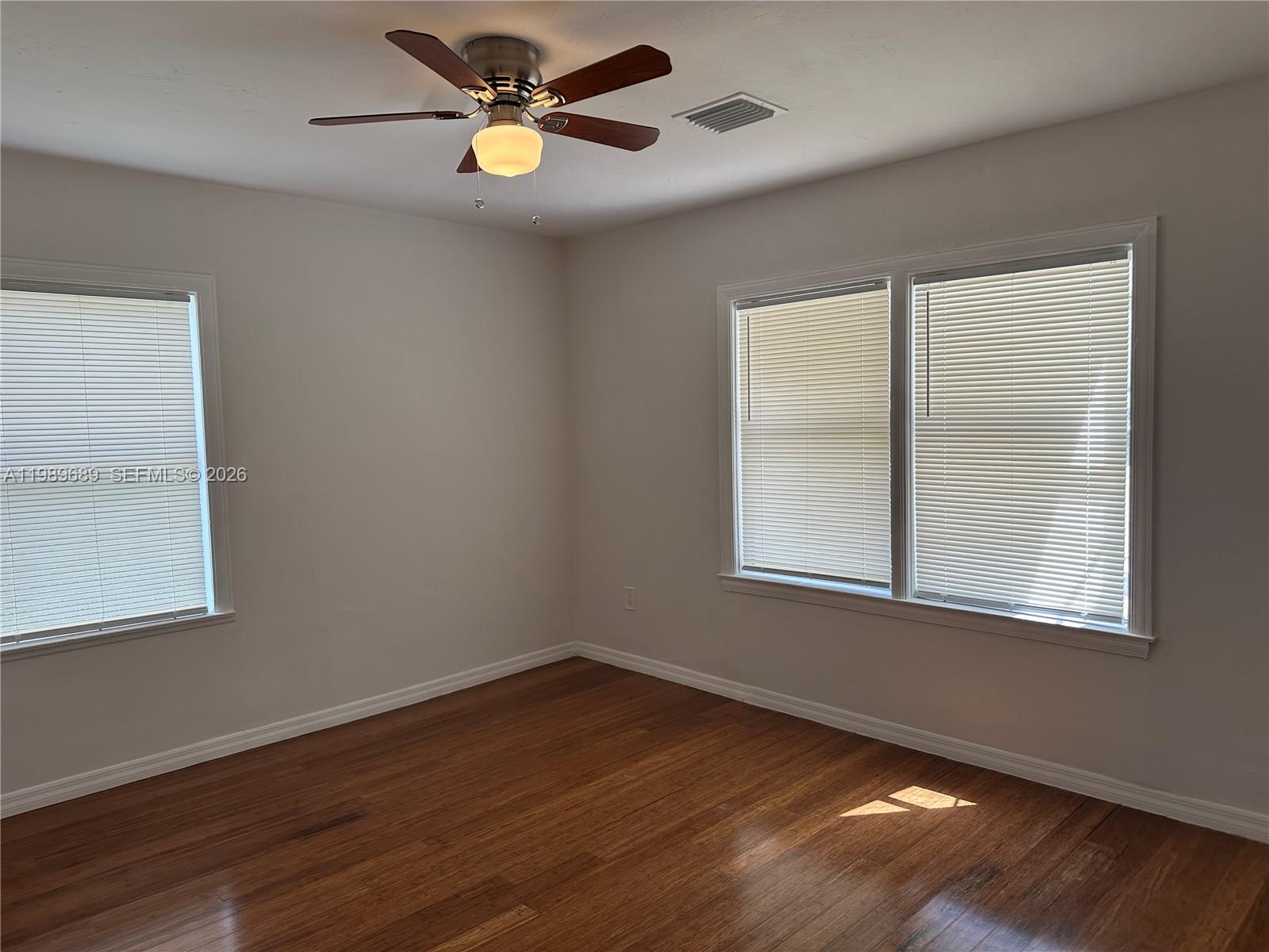 1441 Northeast 134th Road, Unit 2 North Miami, FL 33161 - Photo 9 of 16 a view of an empty room with wooden floor and a window