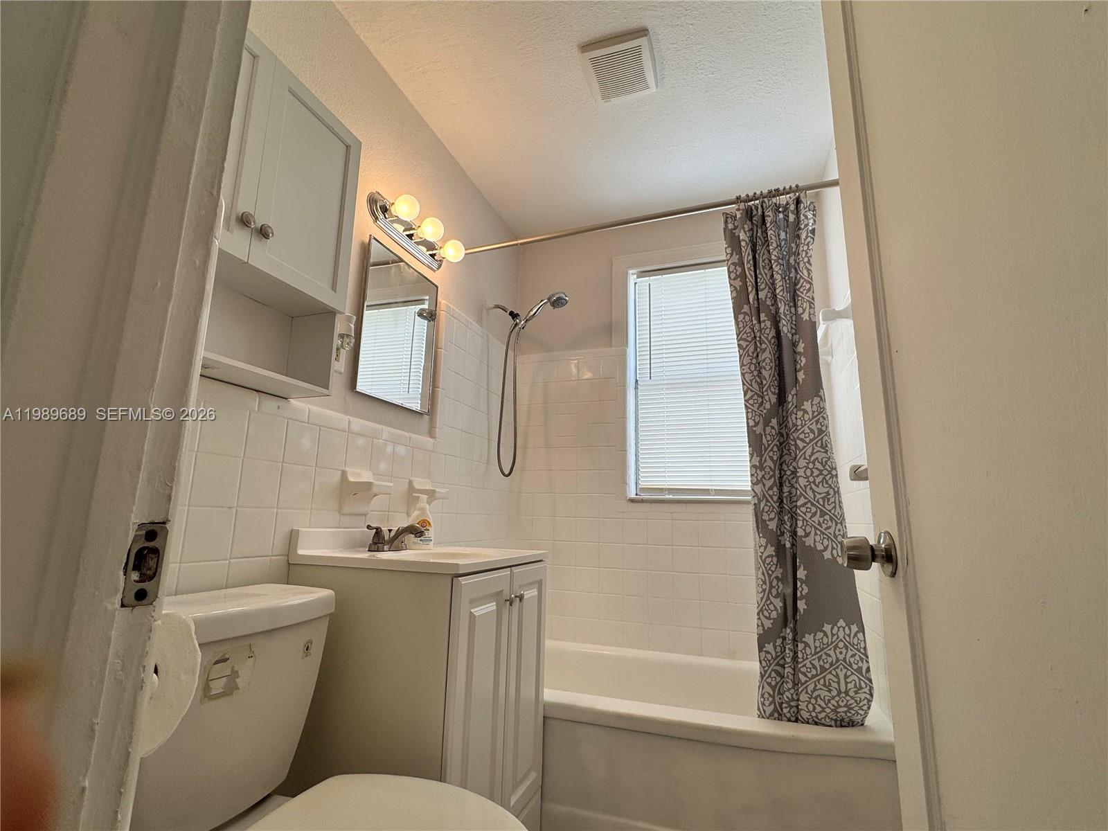 1441 Northeast 134th Road, Unit 2 North Miami, FL 33161 - Photo 10 of 16 a bathroom with a granite countertop sink mirror vanity and toilet